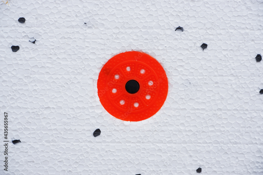 Wall insulation made of pinoplast. Texture with black splashes and red fasteners. Wall insulation made of pinoplast. Texture with black splashes and red fasteners.