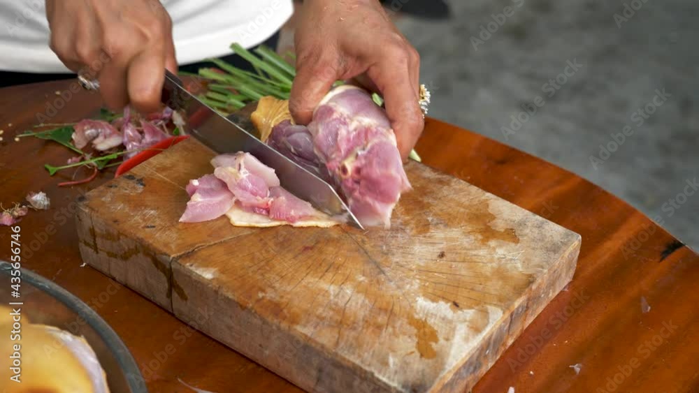 Chef cutting chicken wing on wooden table for Tom Kha Kai soup Chef cutting chicken wing on wooden table for Tom Kha Kai soup