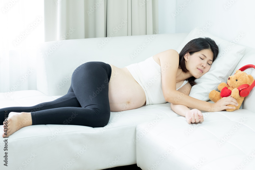 Young beautiful pregnant woman taking a rest, sleeping on a sofa in her home. Young beautiful pregnant woman taking a rest, sleeping on a sofa in her home.