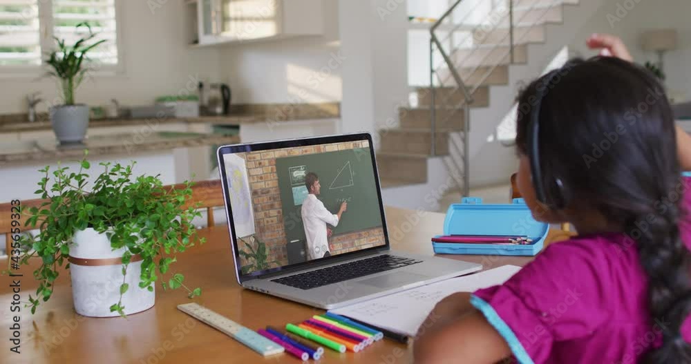 African american girl raising her hand while having a video call with male teacher on laptop at home African american girl raising her hand while having a video call with male teacher on laptop at home