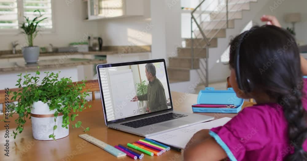 African american girl raising her hand while having a video call with male teacher on laptop at home African american girl raising her hand while having a video call with male teacher on laptop at home