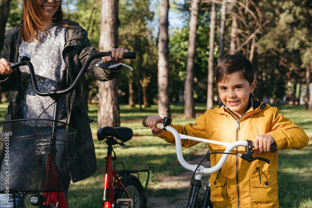 Obraz premium mother and her child in public park with bicycles