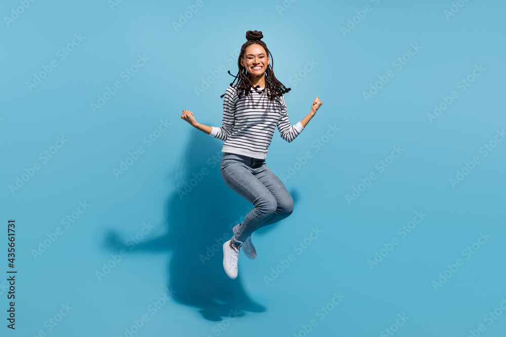 Full body profile side photo of young african girl happy positive smile jump rejoice victory isolated over blue color background