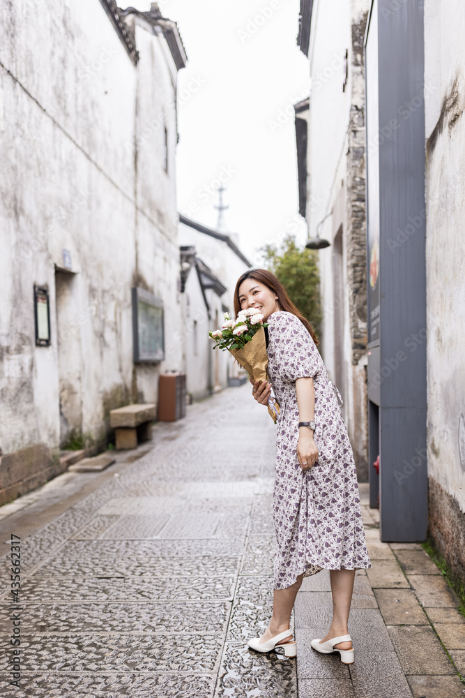 Portrait of young asian woman wearing stylish summer dress and walking outdoor in old city. Happy stylish woman with smiley face enjoys life