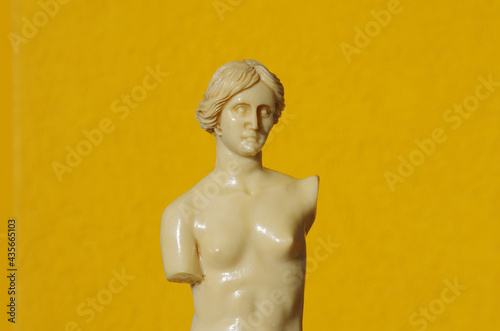 Scale reproduction of the statue of Venus de Milo on an orange background
