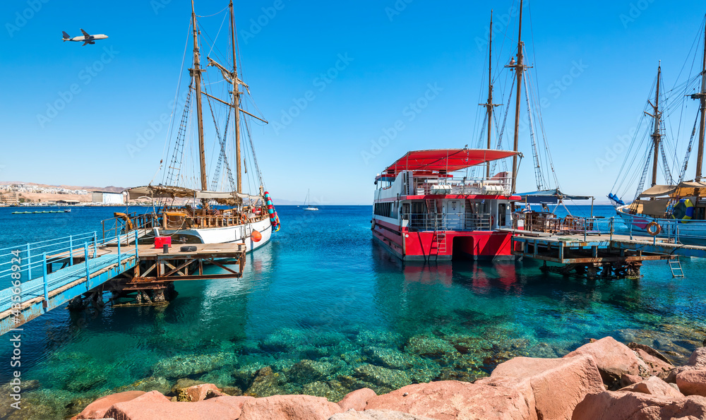 Obraz premium Moored pleasure boats, sailboats and yachts in marina of Eilat - famous resort and recreation city in Israel
