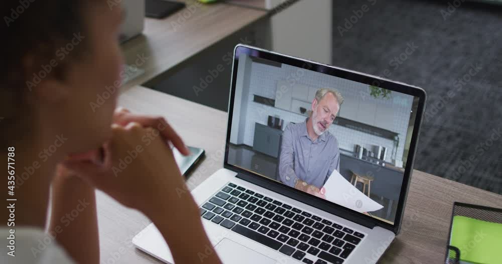 Mid section of african american woman having a video call on laptop with male colleague at office