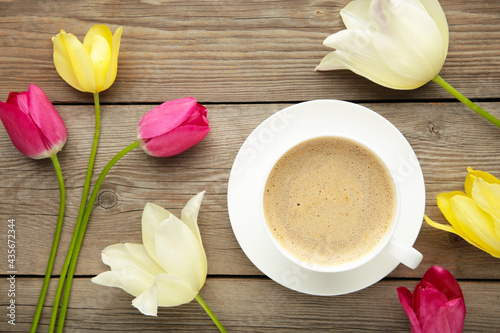 Fototapeta Naklejka Na Ścianę i Meble -  Cup of coffee with tulips on grey wooden background