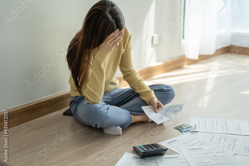 stressed young asian woman trying to find money to pay credit card deb photo