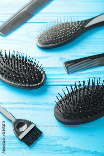 Hair tools  beauty and hairdressing concept - different brushes or combs on blue background. Vertical photo