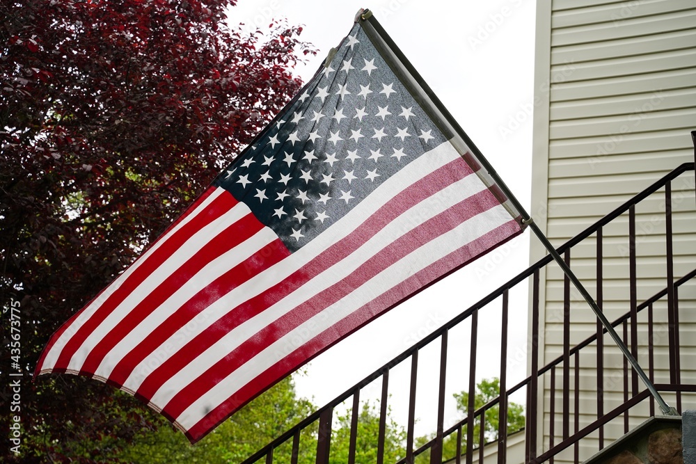 American flag placed outside of a home front - Untied states memorial day concept