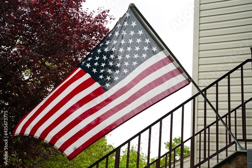 American flag placed outside of a home front - Untied states memorial day concept