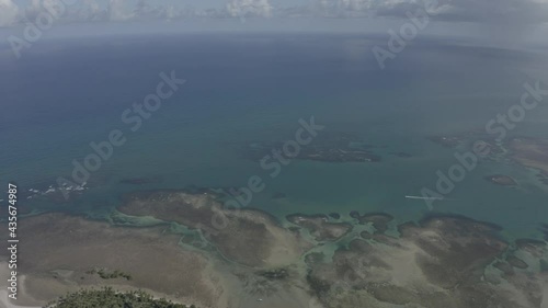 Vue de drone circulaire de l'océan, marée basse, un bateau qui avance. Été à Praia Bainema Bahia, Brésil. Paysage tropical avec palmiers, sable, eau, coraux, bateau photo