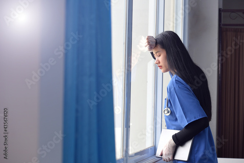 Nurses worked hard and tired Medical team nurses feeling tired and sad from working to cure patients during the covid 19 pandemics young woman takes a break sitting close to her eyes and rest.