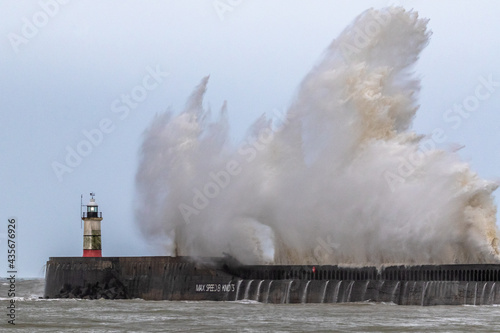 Waves crash over Newhaven harbour wall during a storm.