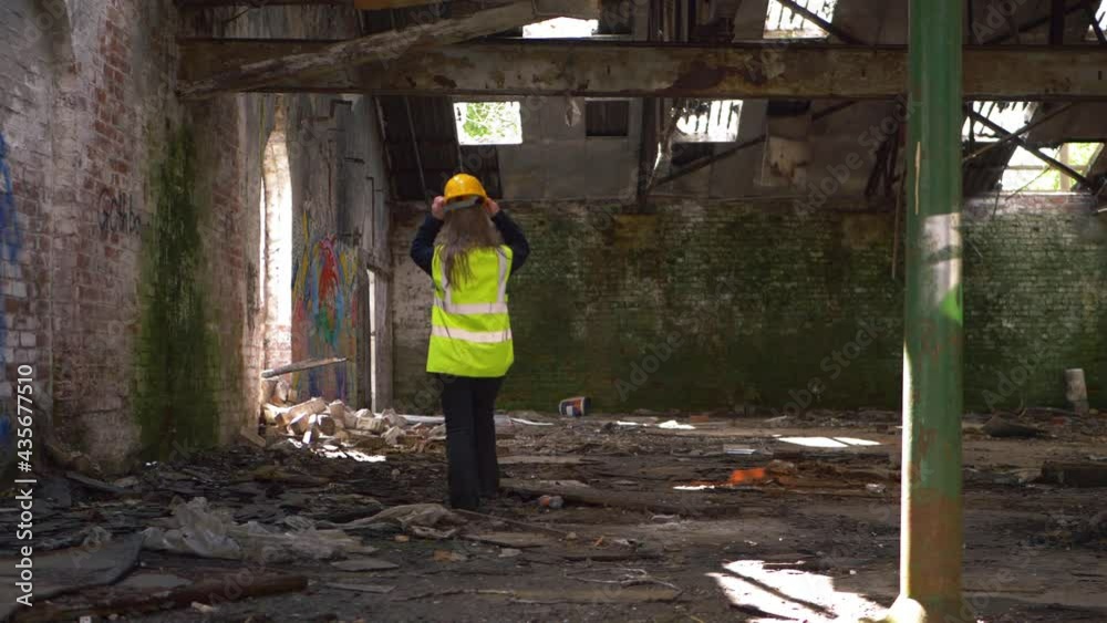 Worker walks through demolished building Worker walks through demolished building