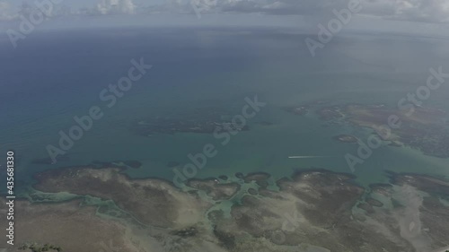 Vue de drone de droite à gauche de l'océan, marée basse, un bateau qui avance Été à Praia Bainema Bahia, Brésil. Paysage tropical avec palmiers, sable, eau, coraux, bateau photo