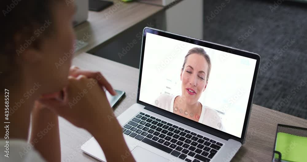 Mid section of african american woman having a video call with female colleague on laptop at office Mid section of african american woman having a video call with female colleague on laptop at office