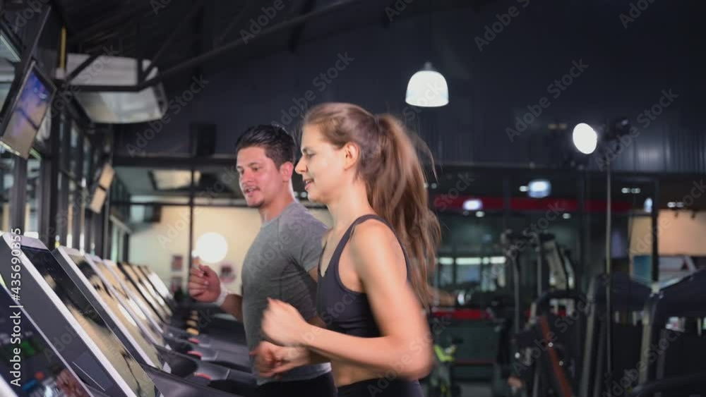 Couple of Happy Caucasian Running Exercising Cardio on Electric Treadmill for Healthy in Gym. Athlete Young Woman and Man in Sportswear Jogging Workout on Treadmills in Fitness Health Club Center. Couple of Happy Caucasian Running Exercising Cardio on Electric Treadmill for Healthy in Gym. Athlete Young Woman and Man in Sportswear Jogging Workout on Treadmills in Fitness Health Club Center.