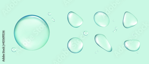 Photo Set of transparent water drops of different shapes isolated on a blue background