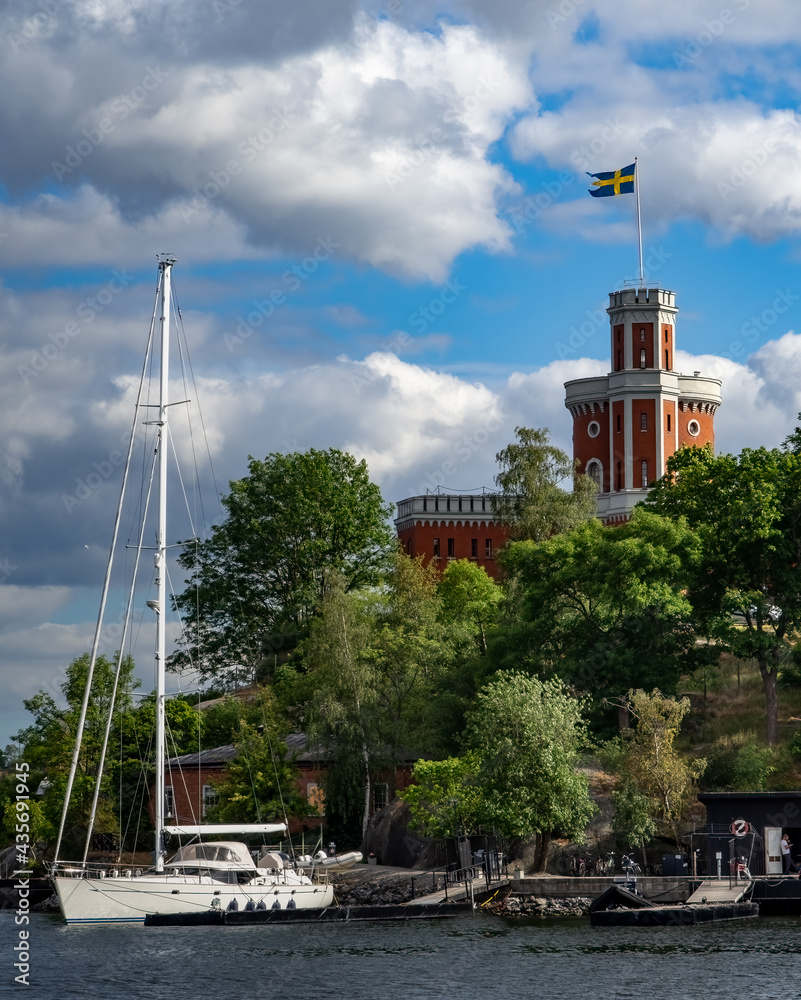Beautiful white sailboat at dock with Stockholm castle flying Swedish flag in the background.