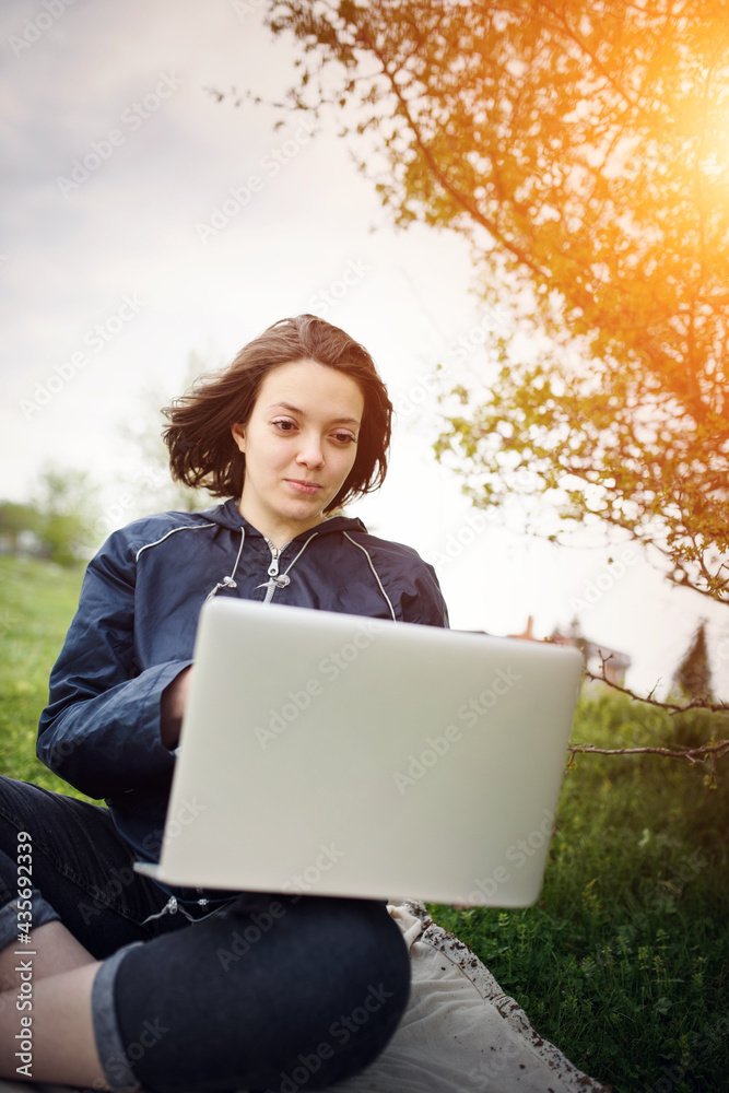 a woman works on a laptop while sitting in nature during the coronavirus pandemic. High quality photo a woman works on a laptop while sitting in nature during the coronavirus pandemic. High quality photo