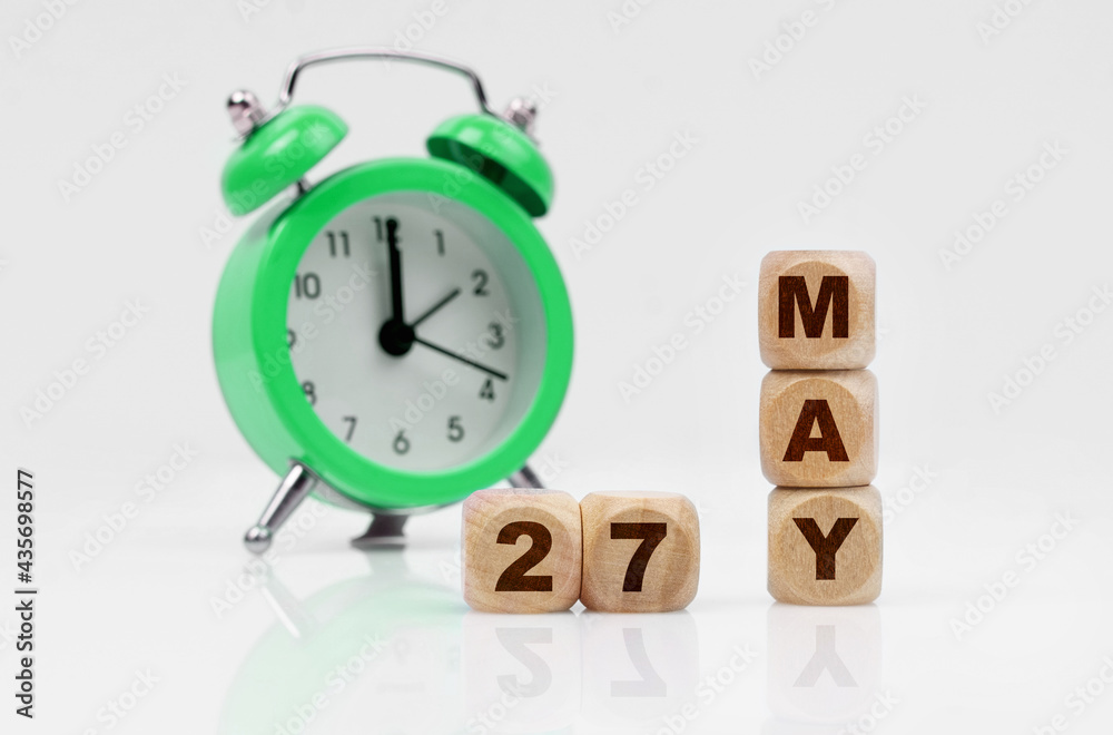 On a white background there is an alarm clock and a calendar with the inscription - MAY 27 On a white background there is an alarm clock and a calendar with the inscription - MAY 27