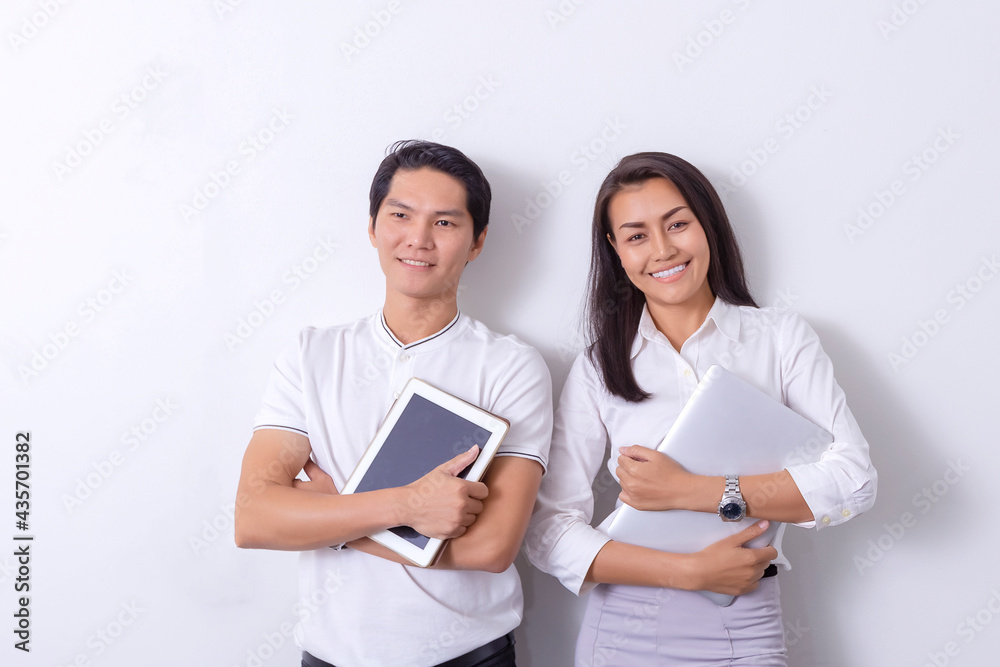 An Asian business woman standing in a modern collaborative office, smiling, looking at the screen of a tablet device, preparing a presentation about electronic devices. An Asian business woman standing in a modern collaborative office, smiling, looking at the screen of a tablet device, preparing a presentation about electronic devices.