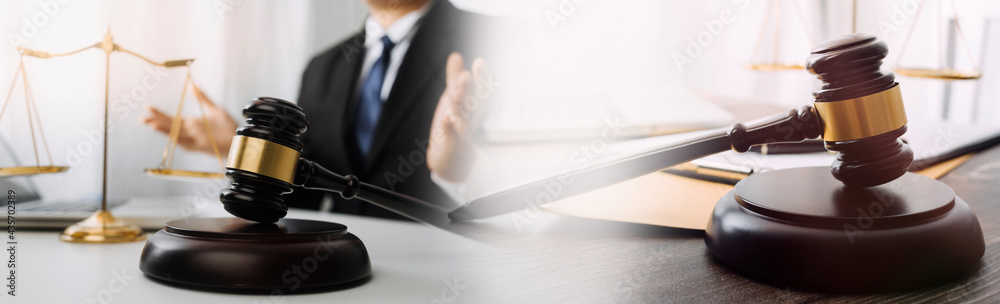 Business and lawyers discussing contract papers with brass scale on desk in office. Law, legal services, advice, justice and law concept picture with film grain effect Business and lawyers discussing contract papers with brass scale on desk in office. Law, legal services, advice, justice and law concept picture with film grain effect