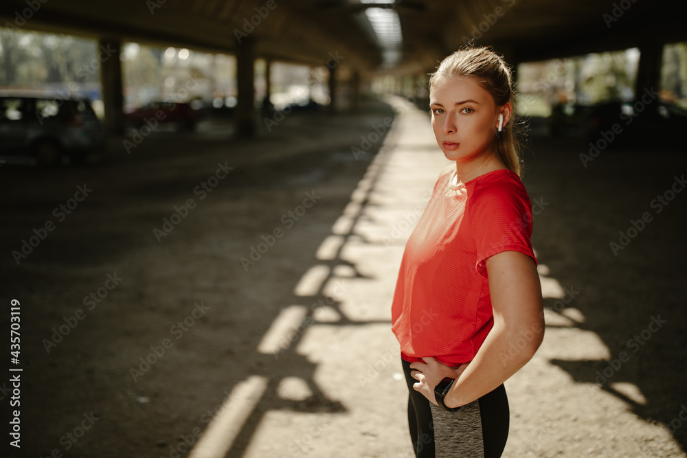 Young female athlete looking at the camera. Motivated and focused sporty woman before a run. Young female athlete looking at the camera. Motivated and focused sporty woman before a run.