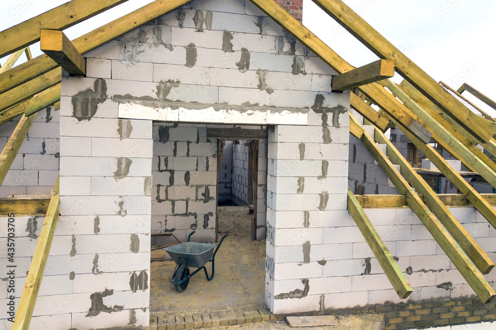 Aerial view of a private house with aerated concrete brick walls and wooden frame for future roof. Aerial view of a private house with aerated concrete brick walls and wooden frame for future roof.
