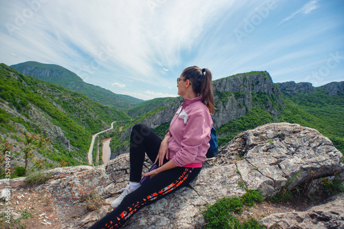 A young woman is sitting on the top of the canyon in Sicevo (Sićevo, Sićevačka klisura) photo