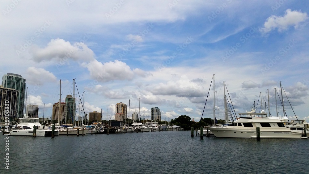 Boats in a marina with white floating clouds