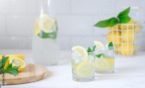 Fresh lemon lemonade with mint in bottle on kitchen table with ingredients. healthy nutrition diet concept. White background.