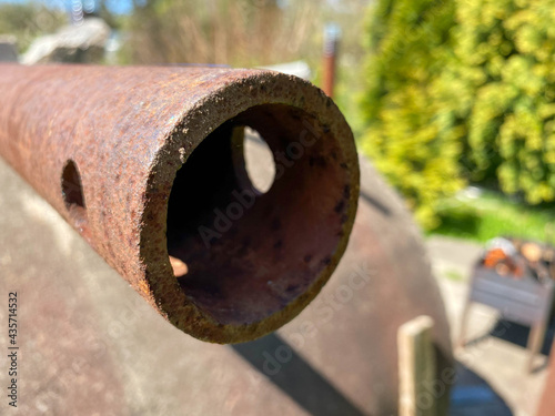 Rusty iron metal industrial pipe of large diameter old with holes for pumping liquid and construction in an oil refinery, petrochemical plant