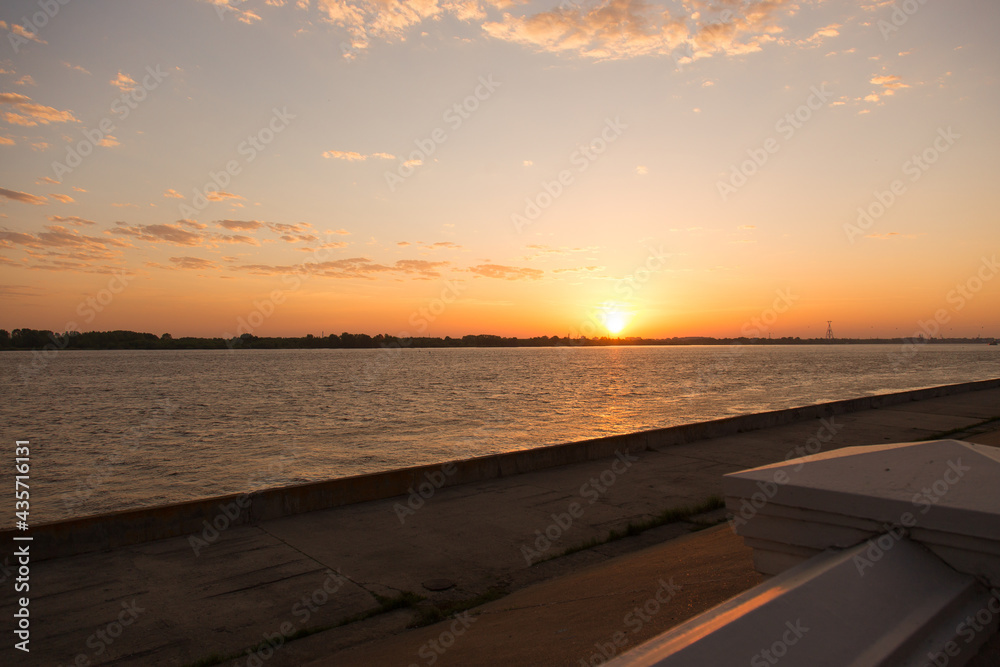 Sunset or sunrise on the river embankment at summer evening