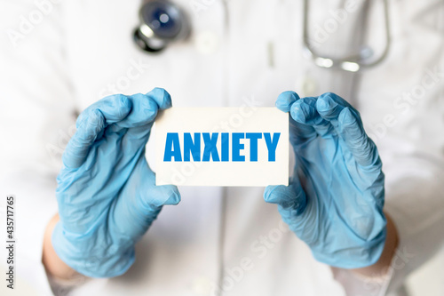 Cuadro en lienzo A medical worker in gloves holds a card with the words ANXIETY