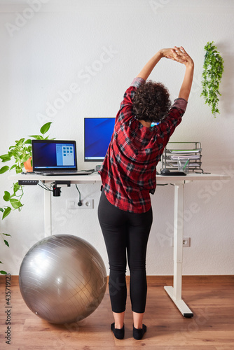 Woman telecommuting at an adjustable standing desk