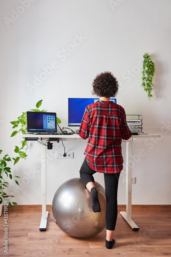 Woman telecommuting at an adjustable standing desk