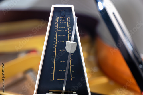 Metronome with pendulum to keep rhythm and tempo for piano, classical music, musicians - close-up with selective focus photo