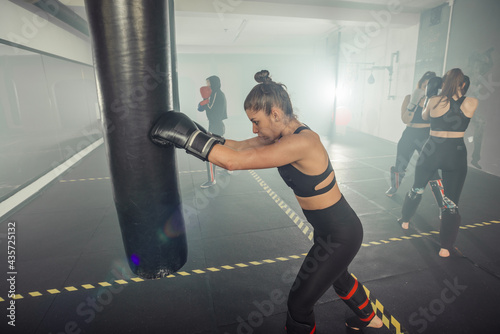 Boxer woman. Boxing fitness woman smiling happy wearing black boxing gloves. Portrait of sporty fit Asian model of boxing gym