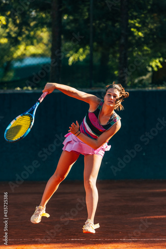 Vertical full-length view of a sportswoman playing match on the tennis court