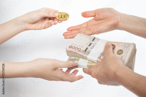 Vászonkép Cropped shot of people hands trading bitcoin token with Thai baht banknotes isolated on white background