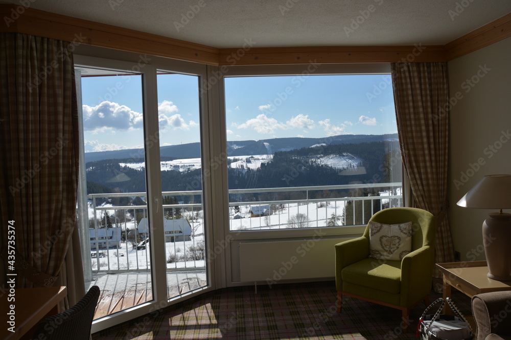 Stunning view of snow covered landscape and cloudy sky from huge panoramic hotel window