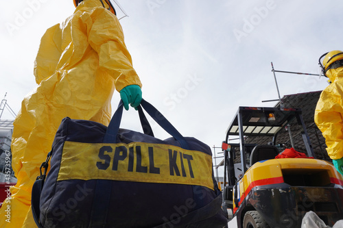 Rescue personnel wear yellow chemical protective clothing during chemical spill recover as part of emergency drills at chemical plant.