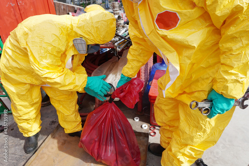 Rescue personnel wear yellow chemical protective clothing during chemical spill recover as part of emergency drills at chemical plant.