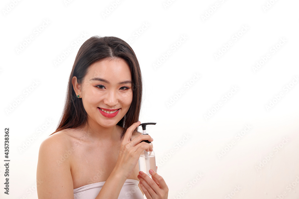 Beautiful young south east Asian woman posing holding squeeze use transparent liquid hand sanitizer plastic bottle pose see offer white background smile Beautiful young south east Asian woman posing holding squeeze use transparent liquid hand sanitizer plastic bottle pose see offer white background smile