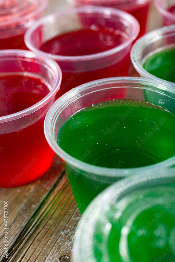 A closeup view of several plastic cups filled with gelatin. A closeup view of several plastic cups filled with gelatin.