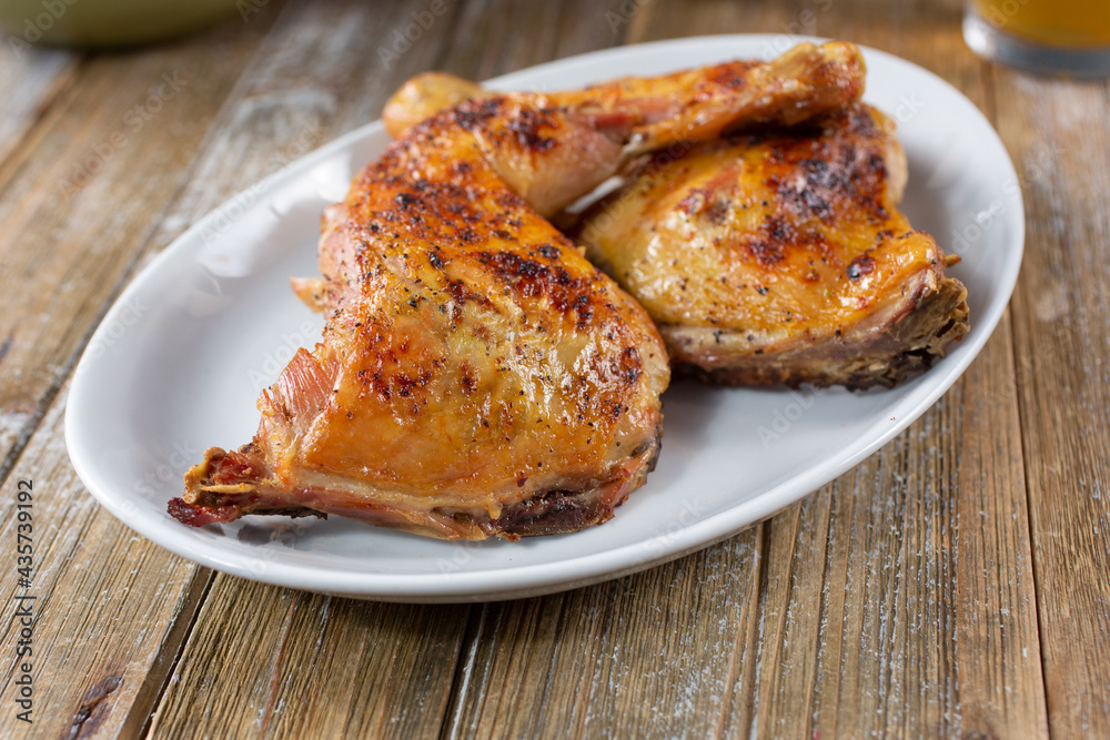 A view of a plate of baked chicken quarters. A view of a plate of baked chicken quarters.