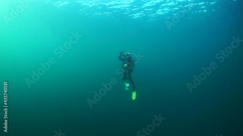 Wallpaper Mural Diver under the surface of the clear water against the sun on blue background. View from underwater deep in Barents Sea. Torontodigital.ca